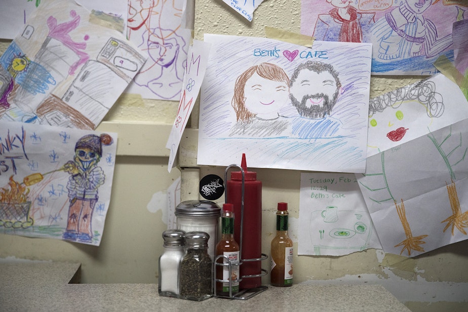 caption: Drawings are taped to a wall on Monday, March 11, 2019, at Beth's Cafe in Seattle.