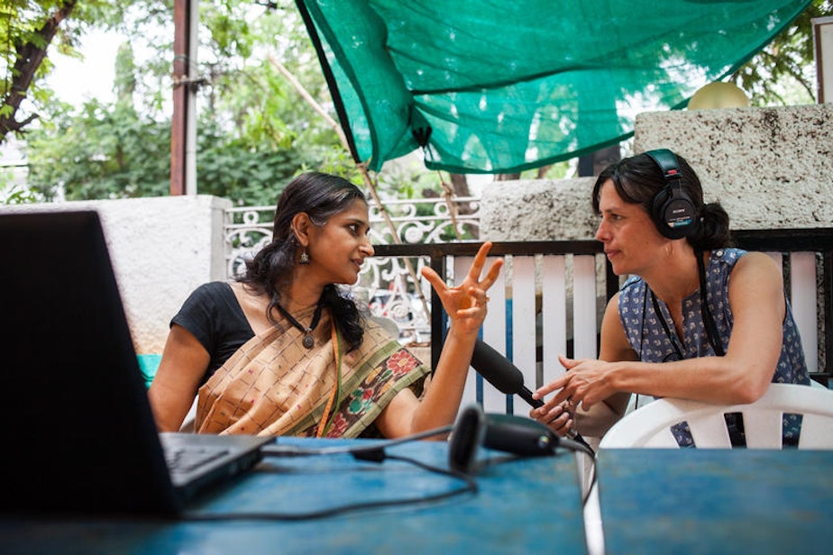 caption: KUOW reporter Liz Jones conducting an interview in a farmers market in Hyderabad, India.