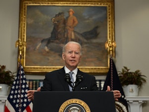 caption: President Biden speaks in the  Roosevelt Room of the White House earlier this month.