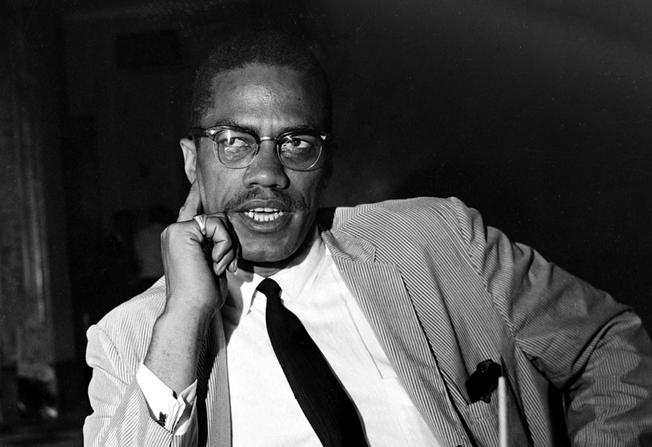 caption: Malcolm X speaks at a news conference in the Hotel Theresa, in New York, May 21,1964. Two of the three men convicted in his 1965 killing are set to be cleared Thursday after insisting through the years that they were not guilty.