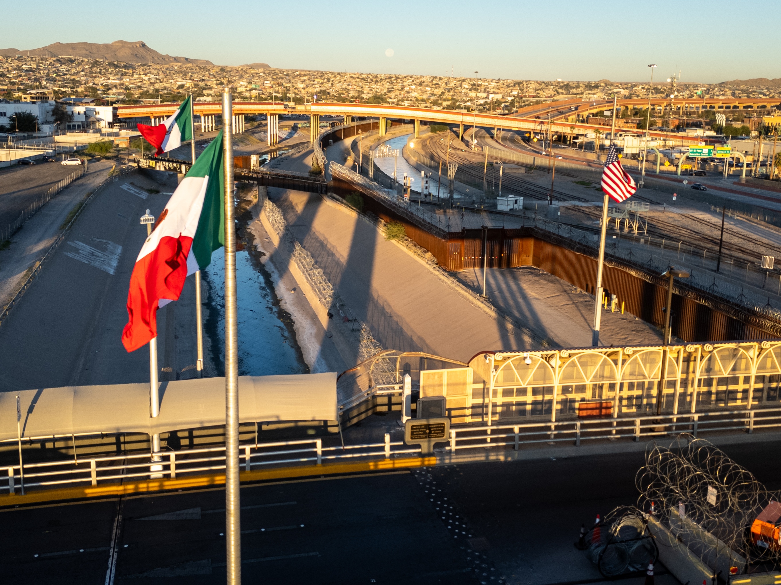 caption: From an aerial view the Mexican and American flags fly over the Rio Grande at the U.S.-Mexico border in El Paso, Texas.