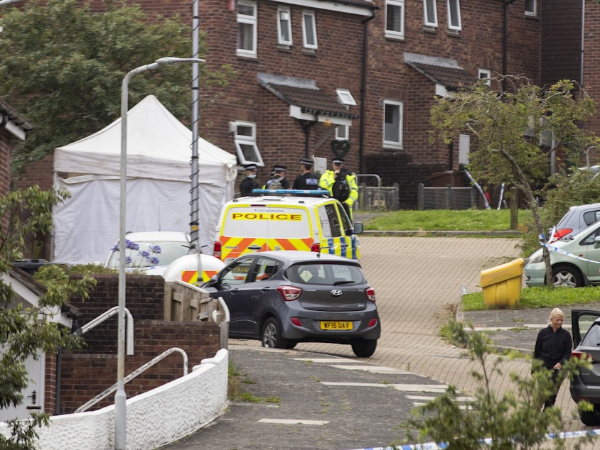 caption: Police work the scene after a deadly shooting in Plymouth, England, on Thursday.