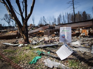 caption: A mobile home park destroyed by last year's wildfire in Paradise, California. Those rebuilding homes and lives say they're getting contradictory messages about whether the water is safe to drink.