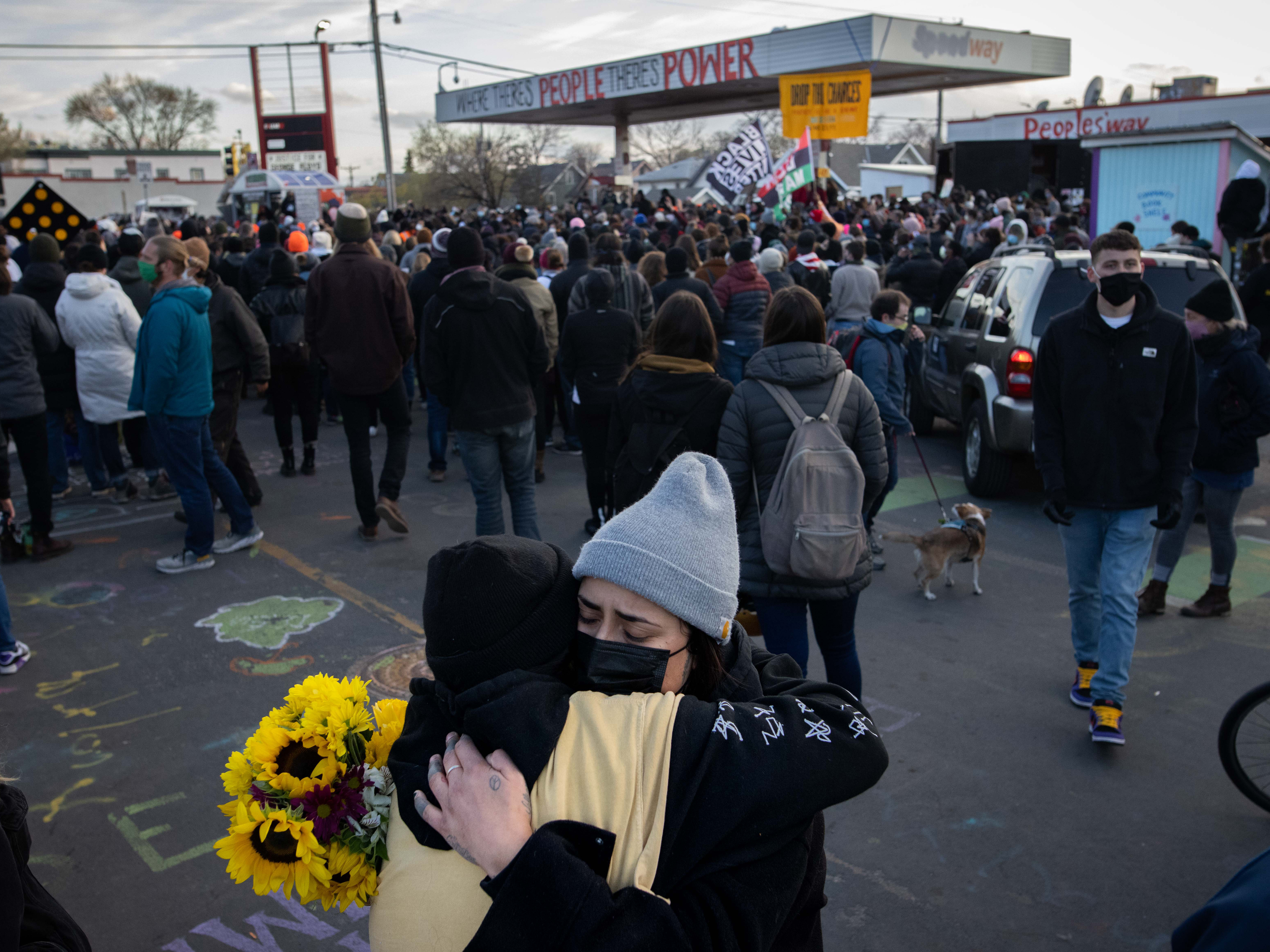 caption: People embrace after the verdict is announced in the trial of former Minneapolis police officer Derek Chauvin at George Floyd Square in Minneapolis, Minn.