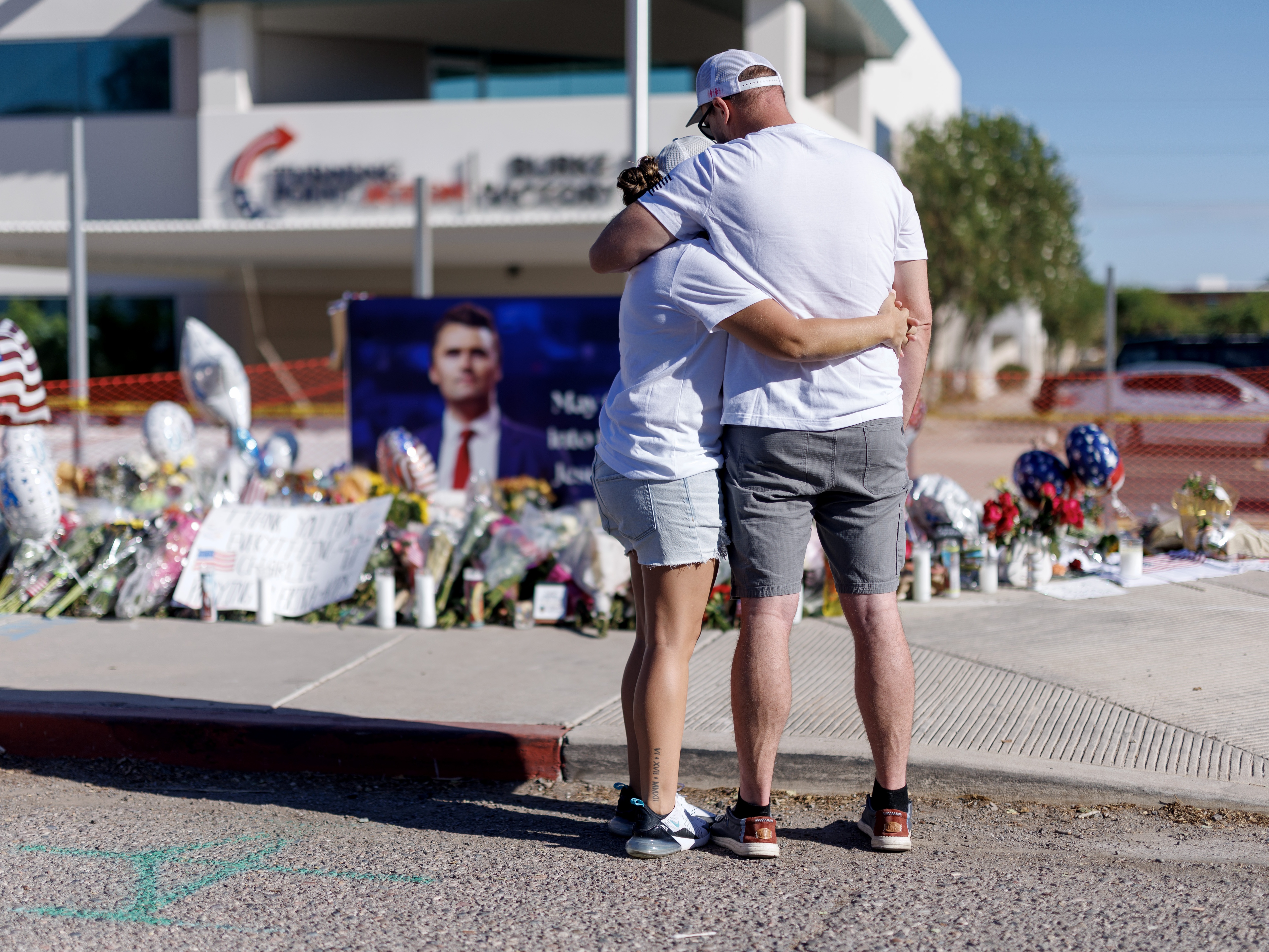 caption: People embrace in front of a memorial for Charlie Kirk at the Turning Point USA headquarters on September 12, 2025 in Phoenix. Kirk, the CEO and co-founder of Turning Point USA, was shot and killed on Wednesday in Utah.