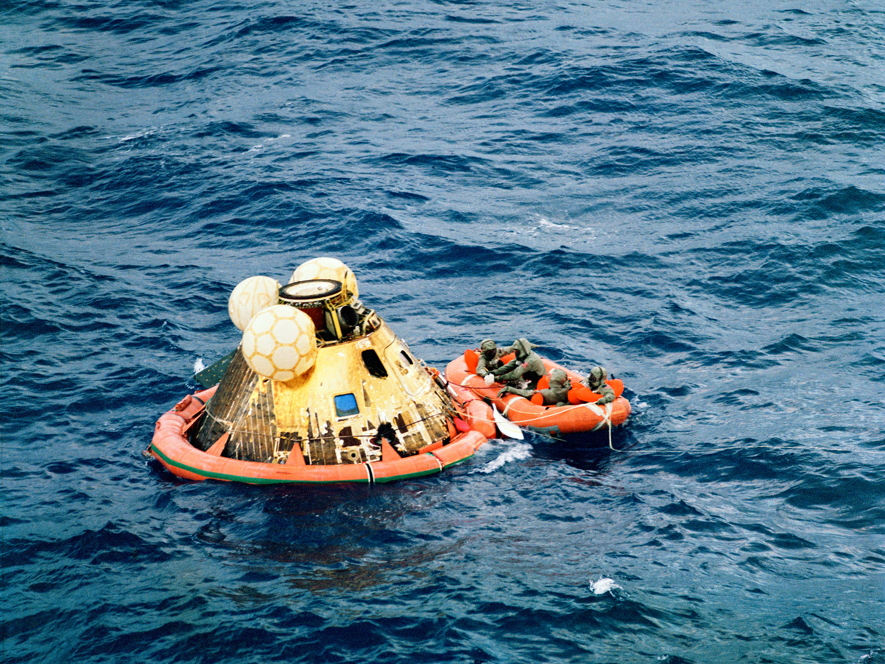caption: The crew of Apollo 11 is picked up after its splashdown.