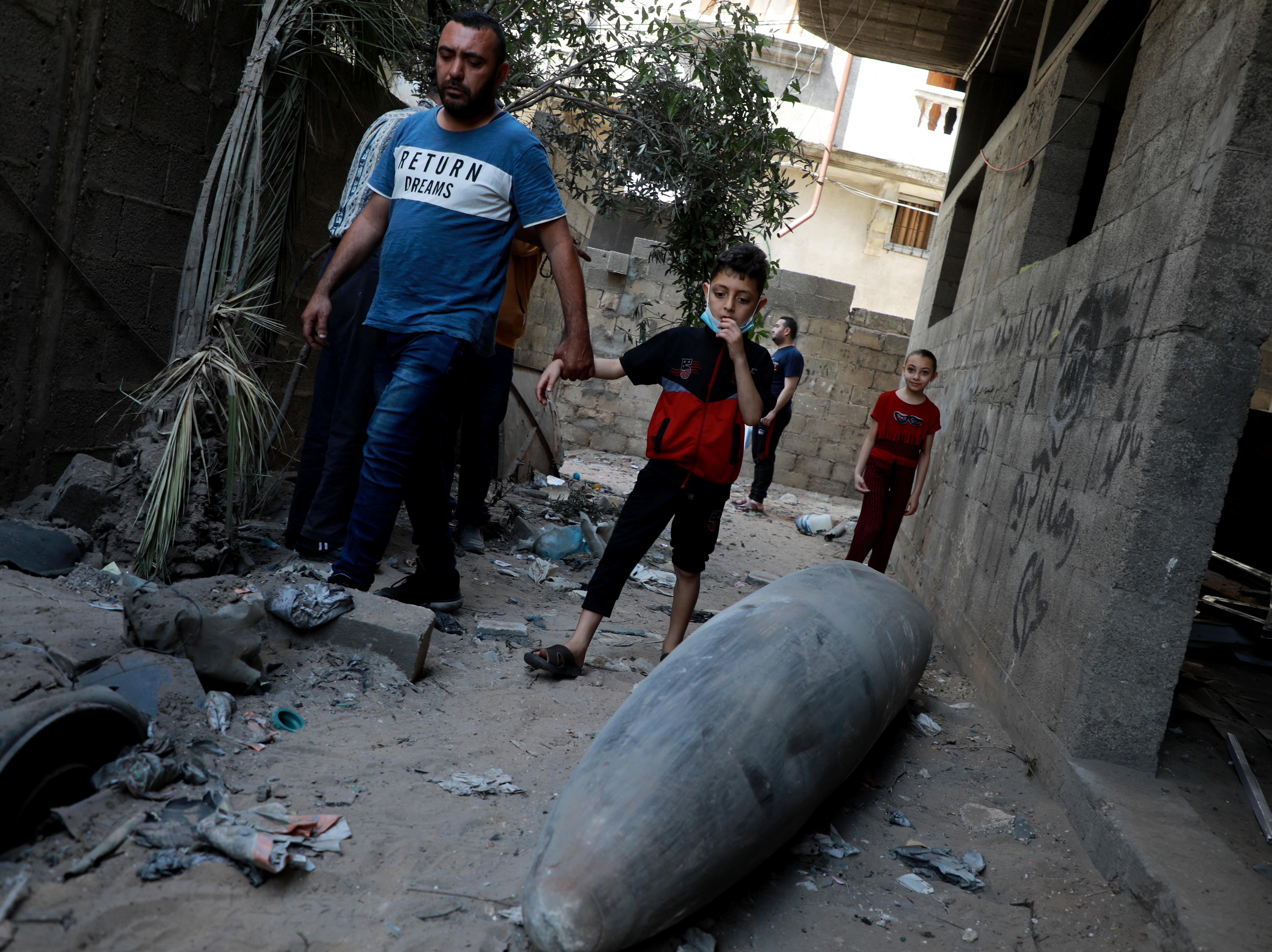 caption: Palestinians look at an unexploded bomb dropped by an Israeli F-16 warplane on Gaza City's Rimal neighbourhood on Tuesday.