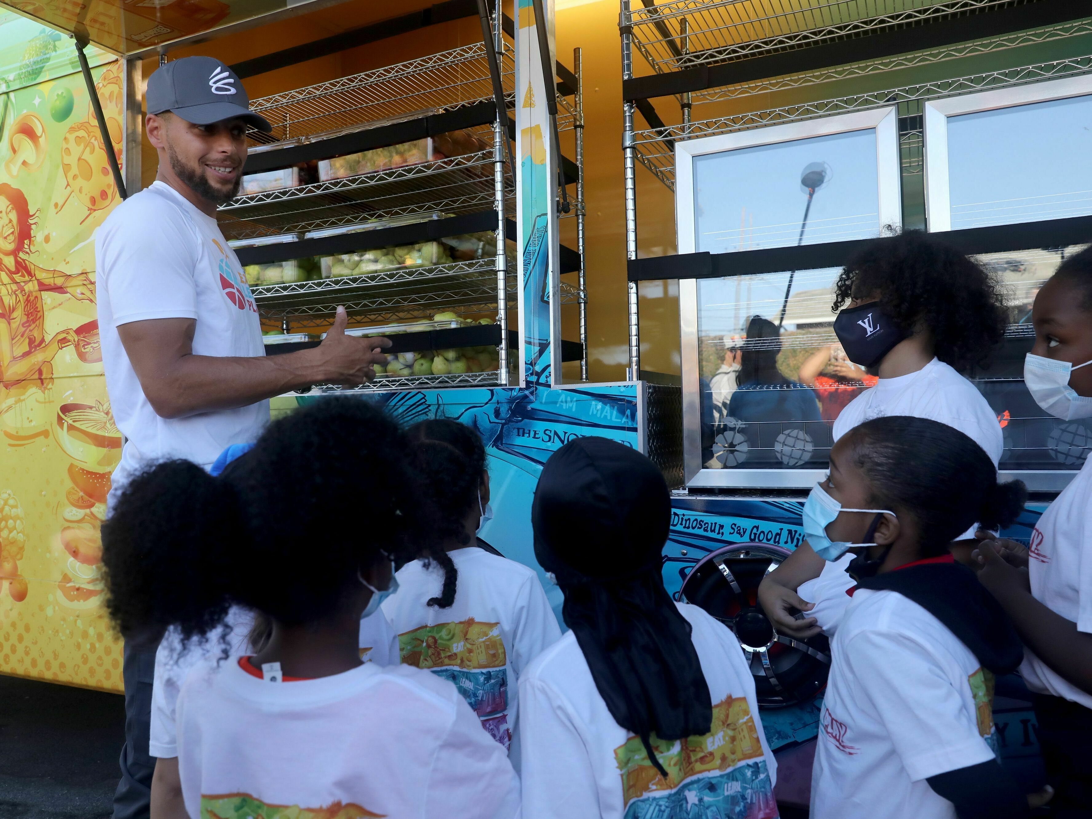 caption: In this 2021 file photo, NBA star Steph Curry talks to kids in Oakland, Calif., about nutrition and exercise.