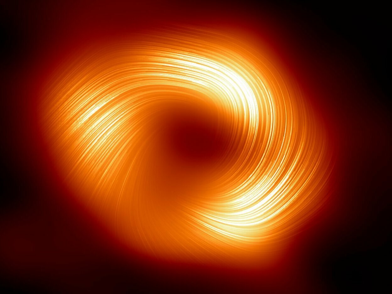 caption: For the first time, we're seeing the Sagittarius A* black hole in polarized light. The Event Horizon Telescope collaboration says the image offers a new look at "the magnetic field around the shadow of the black hole" at the center of the Milky Way.