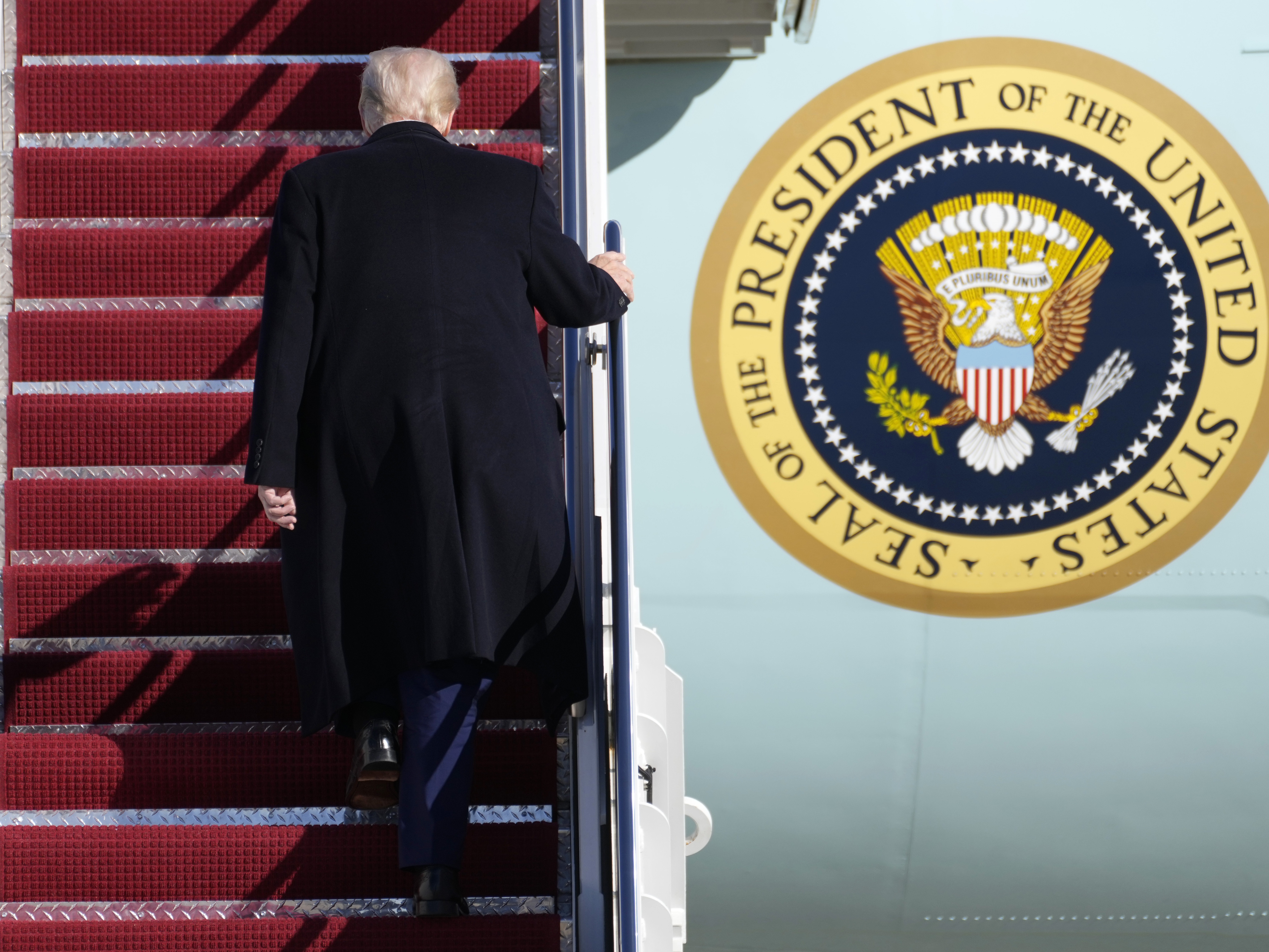 caption: President Trump boards Air Force One in February. He hits the 100-day mark of his presidency this week.