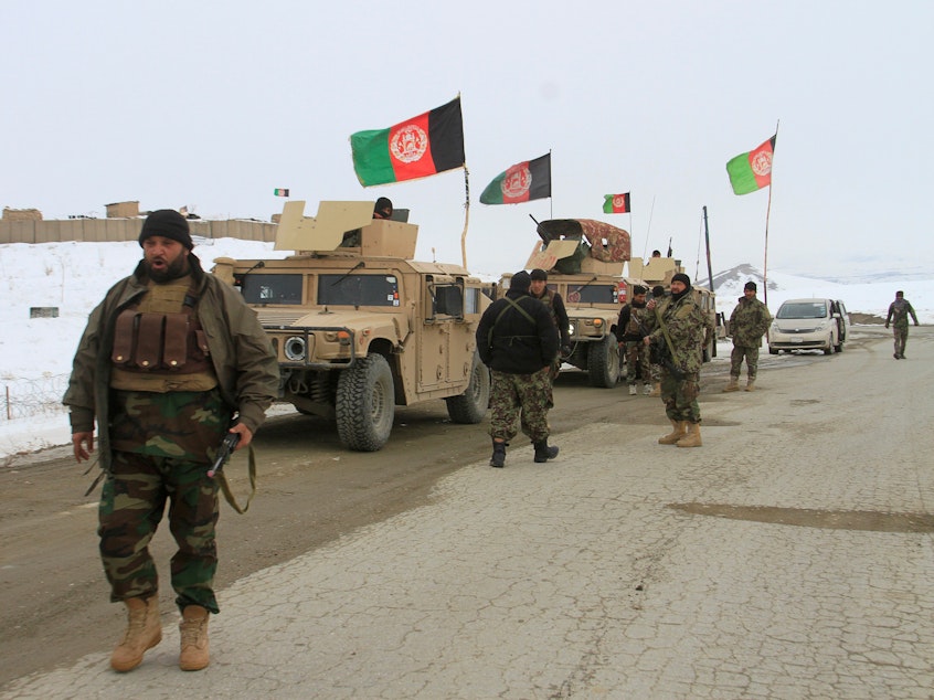 caption: Afghan service members head toward the site of the plane crash Monday in the eastern Afghan province of Ghazni.