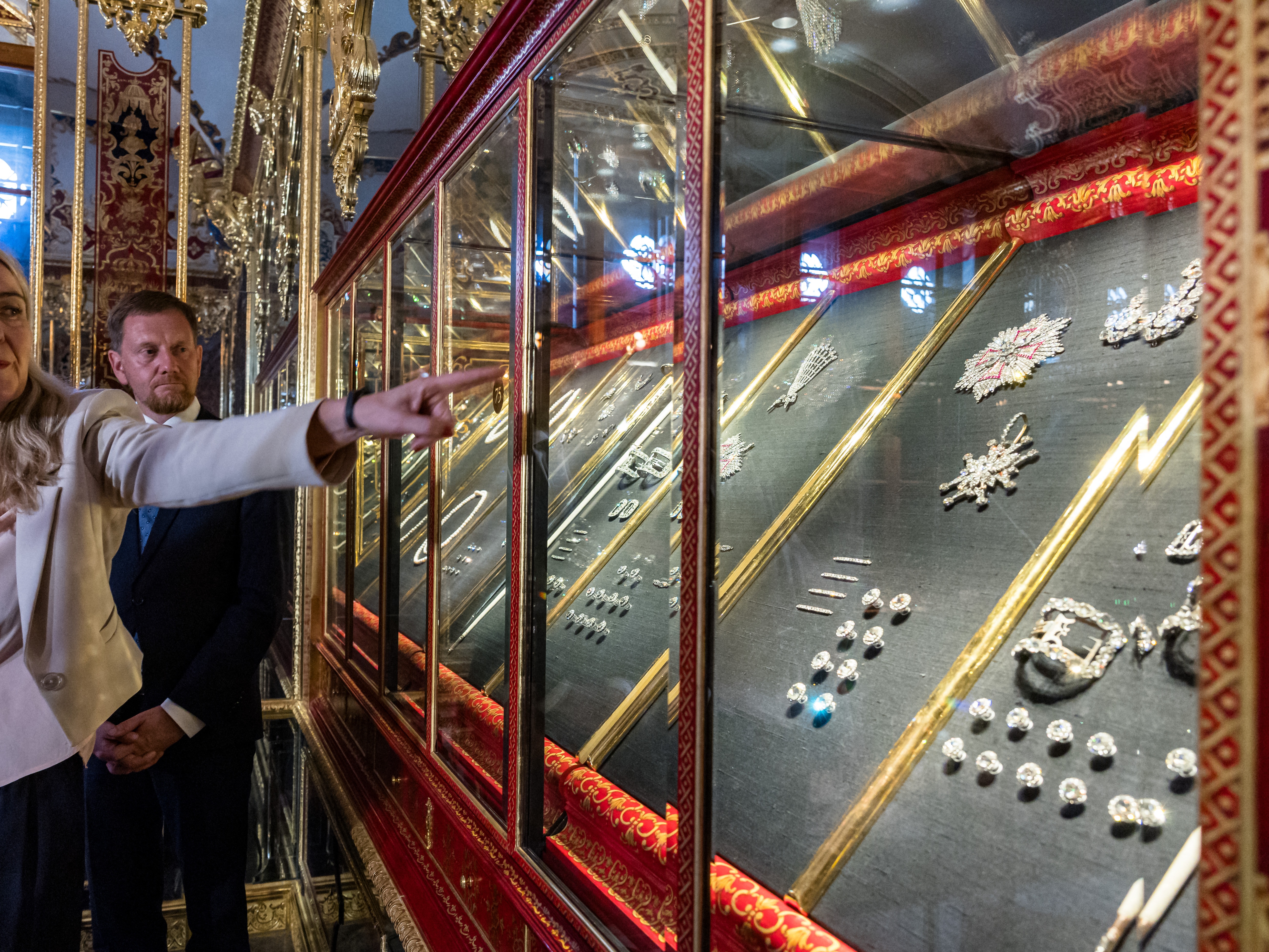 caption: Marion Ackermann, director general of the Dresden State Art Collections, points to a display case with some of the recovered jewelry during a press event at the Green Vault in Dresden, Germany, on Tuesday.