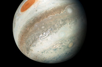 caption: This new perspective of Jupiter from the south makes the Great Red Spot appear as though it is in northern territory. This view is unique to Juno.