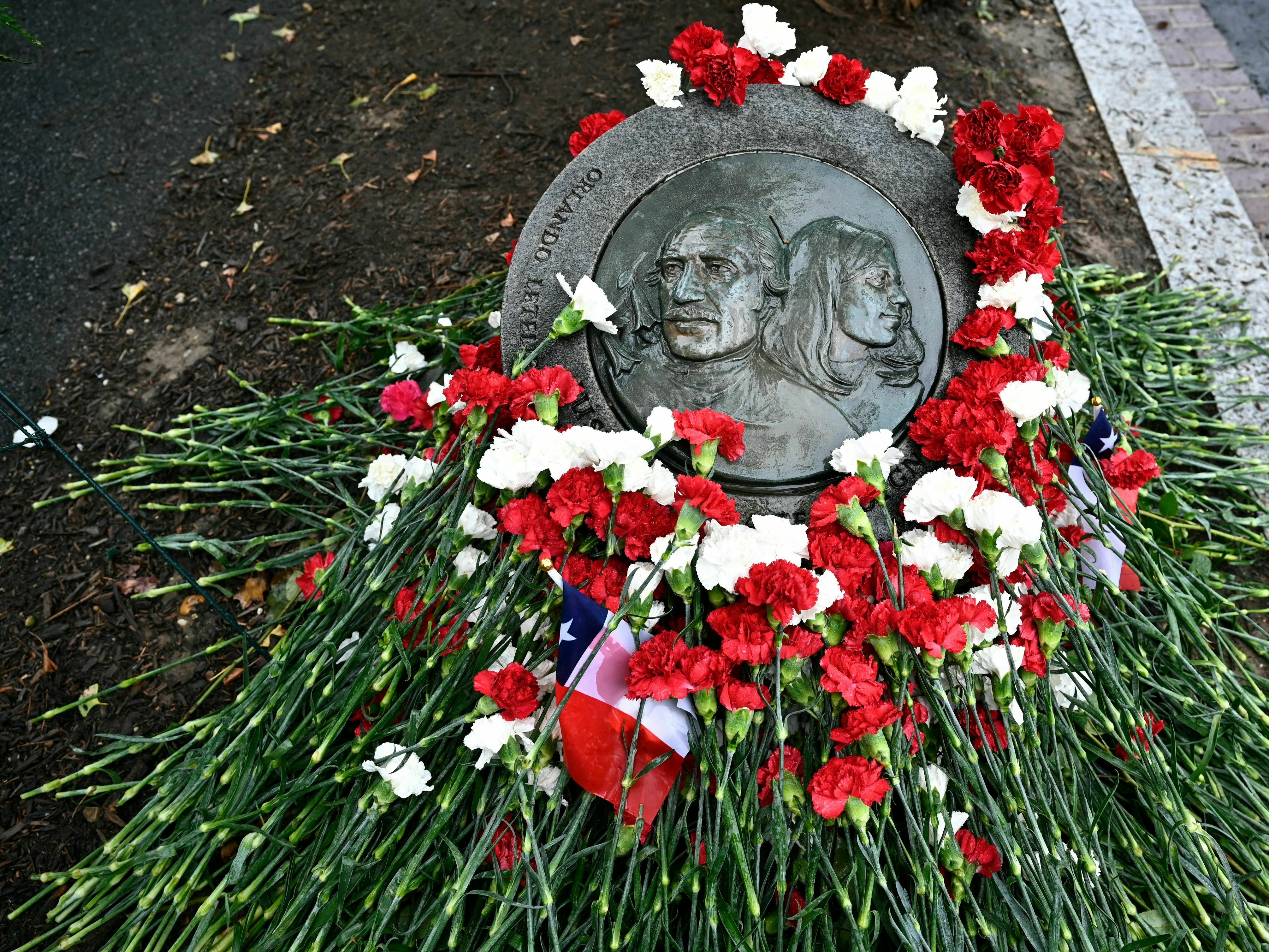 caption: Flowers adorn the memorial plaque at the site where Orlando Letelier and Ronni Moffitt where killed in Washington, D.C. They were killed in a car bomb on Sept. 21, 1976, by agents of Chilean dictator Augusto Pinochet as they drove to work at the Institute for Policy Studies.