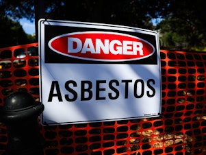 caption: An asbestos warning sign is seen at Victoria Park in in Sydney, Australia on February 29, 2024.