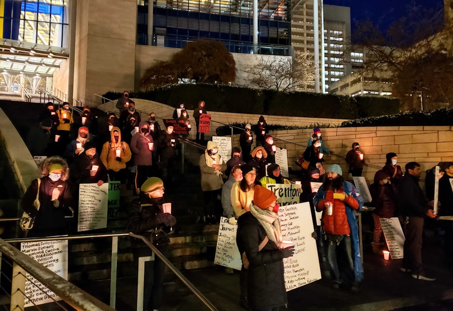 caption: Volunteers hold vigil for unhoused people who died in King County this year outside Seattle City Hall on Wednesday, Dec. 21, 2022.