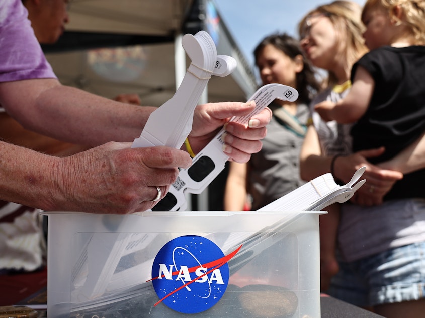 caption: People visit a NASA information booth to grab solar eclipse glasses in Russellville, Arkansas. The space agency has debunked a number of myths about the total solar eclipse — including ideas about food going bad, or unborn babies being harmed.