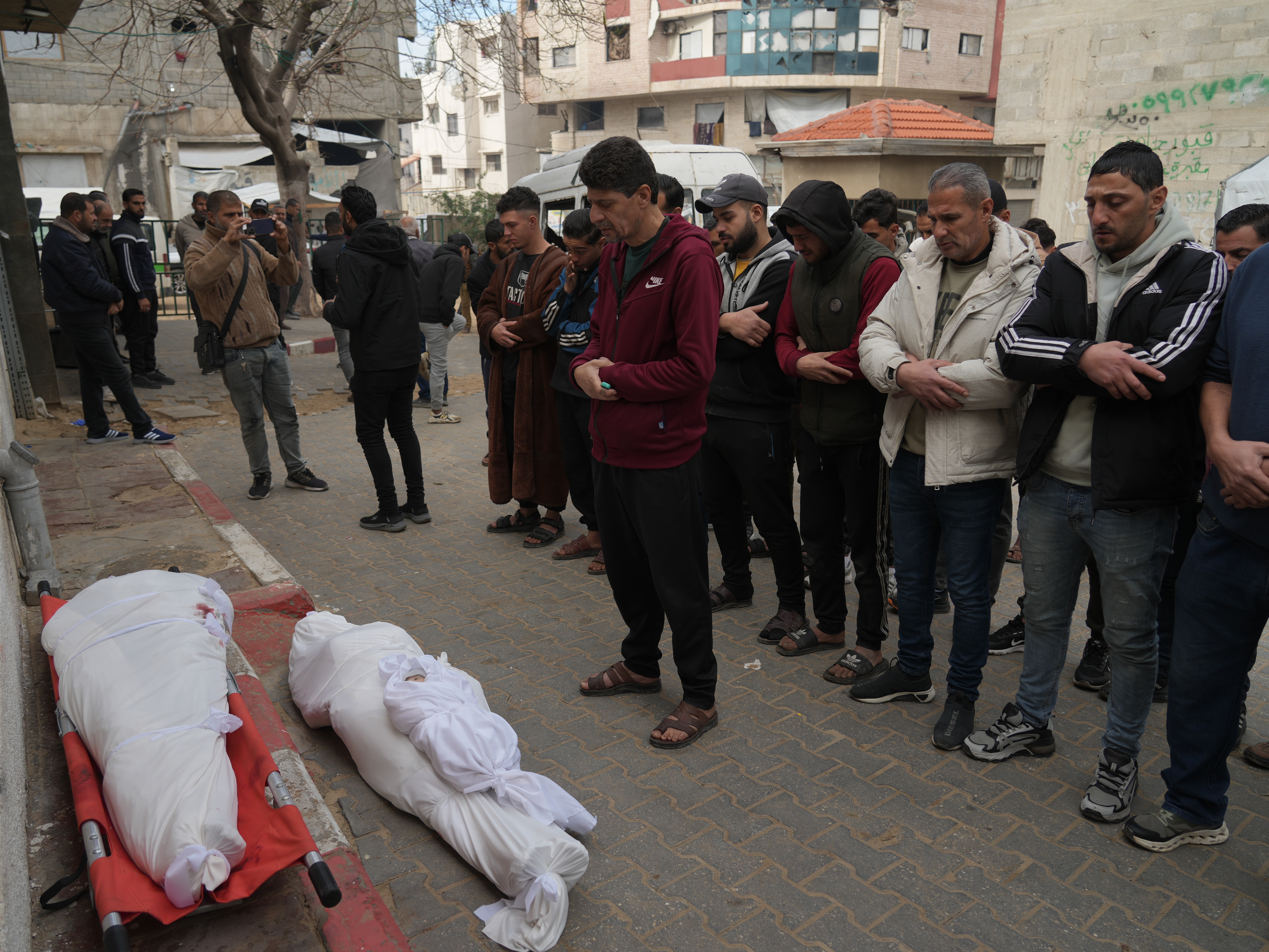 caption: Palestinians mourn over the dead who were killed in an Israeli military strike, at Shifa Hospital in Gaza City, Wednesday, Feb. 4, 2026.