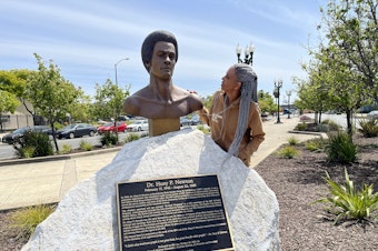 caption: Fredrika Newton stands next the bust of her late husband, Black Panther co-founder Huey P. Newton. NPS is considering a Black Panther Party National Historical Park.