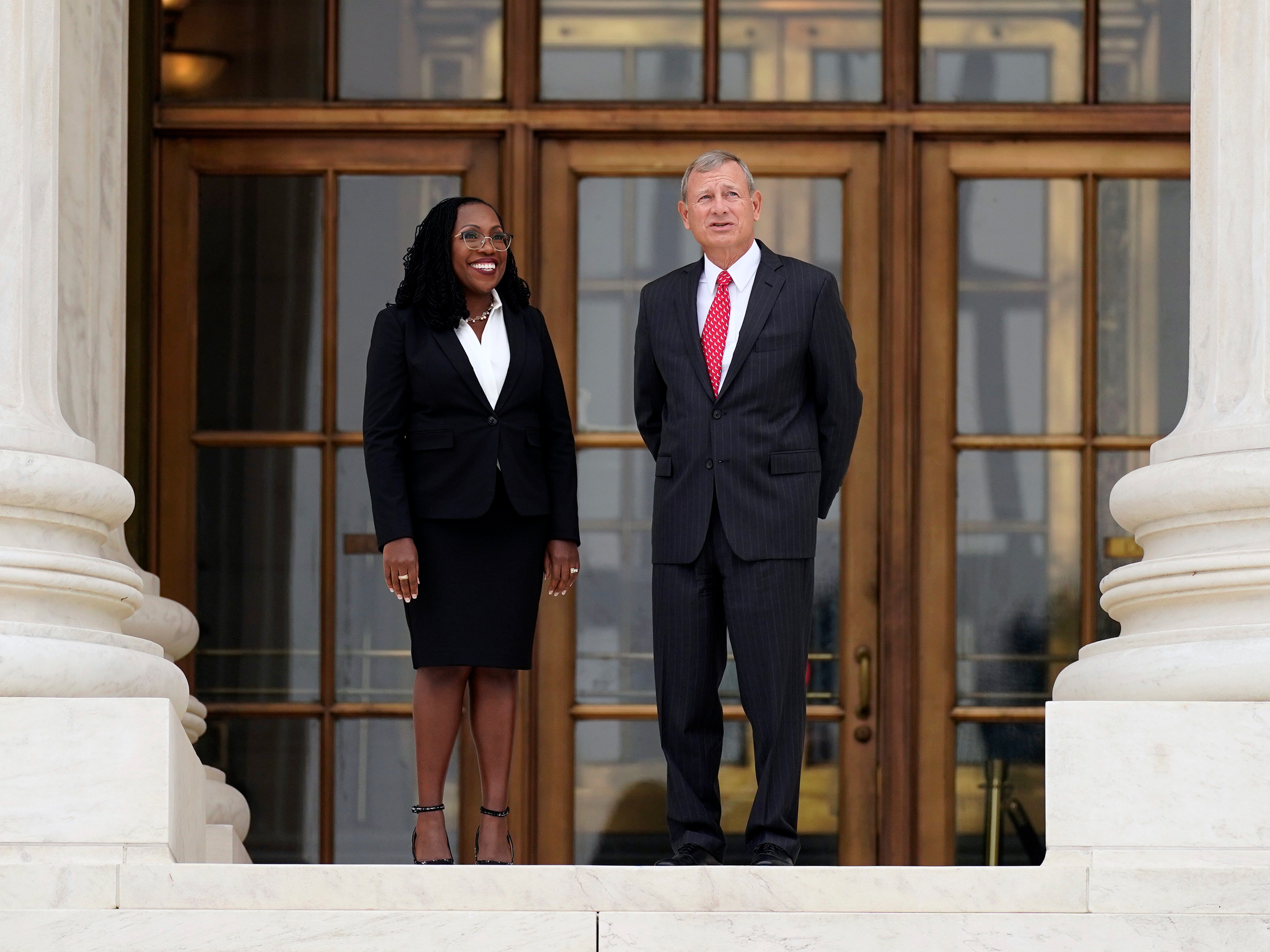 caption: Supreme Court Associate Justice Ketanji Brown Jackson stands outside the Supreme Court with Chief Justice John Roberts, following her formal investiture ceremony at the Supreme Court in Washington on Sept. 30.
