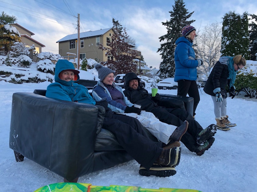 caption: (Left to right) Sean Eley, Renee Grazer and Gabe Goldman set up a couch to sip coffee and watch their kids sled down Juneau in West Seattle.