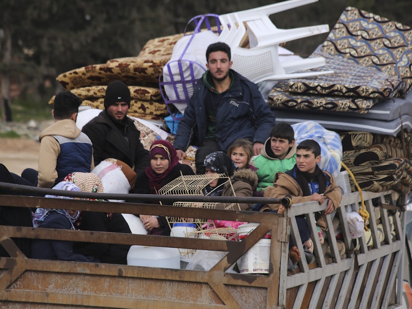 caption: Syrian refugees head northwest through the town of Hazano in Idlib province as the flee renewed fighting Monday, Jan. 27, 2020. (AP Photo/Ghaith Alsayed)