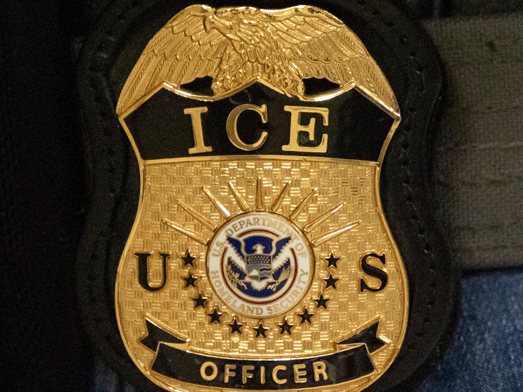 caption: FILE - A federal agent wears an Immigration and Customs Enforcement badge, June 10, 2025, in New York.