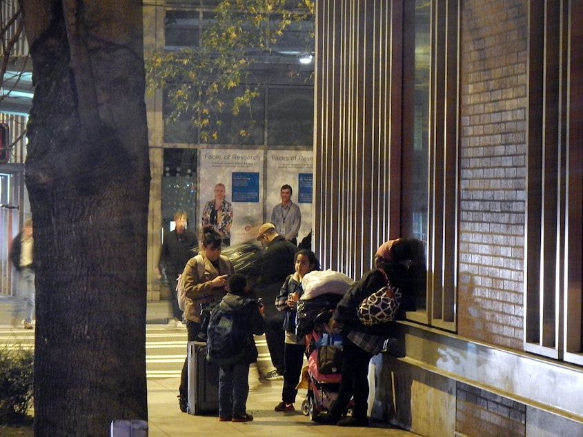 caption: Homeless families outside a shelter in downtown Seattle