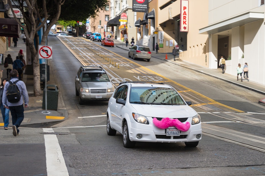 caption: A Lyft for-hire car rolls down a street in San Francisco.