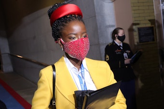 caption: National youth poet laureate Amanda Gorman arrives at the inauguration, dressed head-to-mask-to-toe in bright, primary colors.