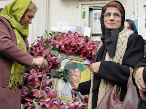 caption: Iranian human rights lawyer Nasrin Sotoudeh with a poster of South Africa's Nelson Mandela, in a scene from the <em>Nasrin </em>documentary.