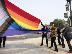 caption: Energy Secretary Jennifer Granholm, center, helps raise a Pride flag outside of the Department of Energy as the Biden administration celebrates Pride Month.