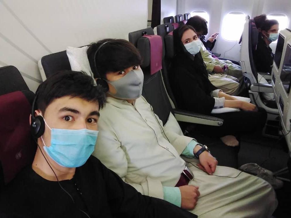 caption: Members of the Afghanistan National Institute of Music on the plane to Doha.