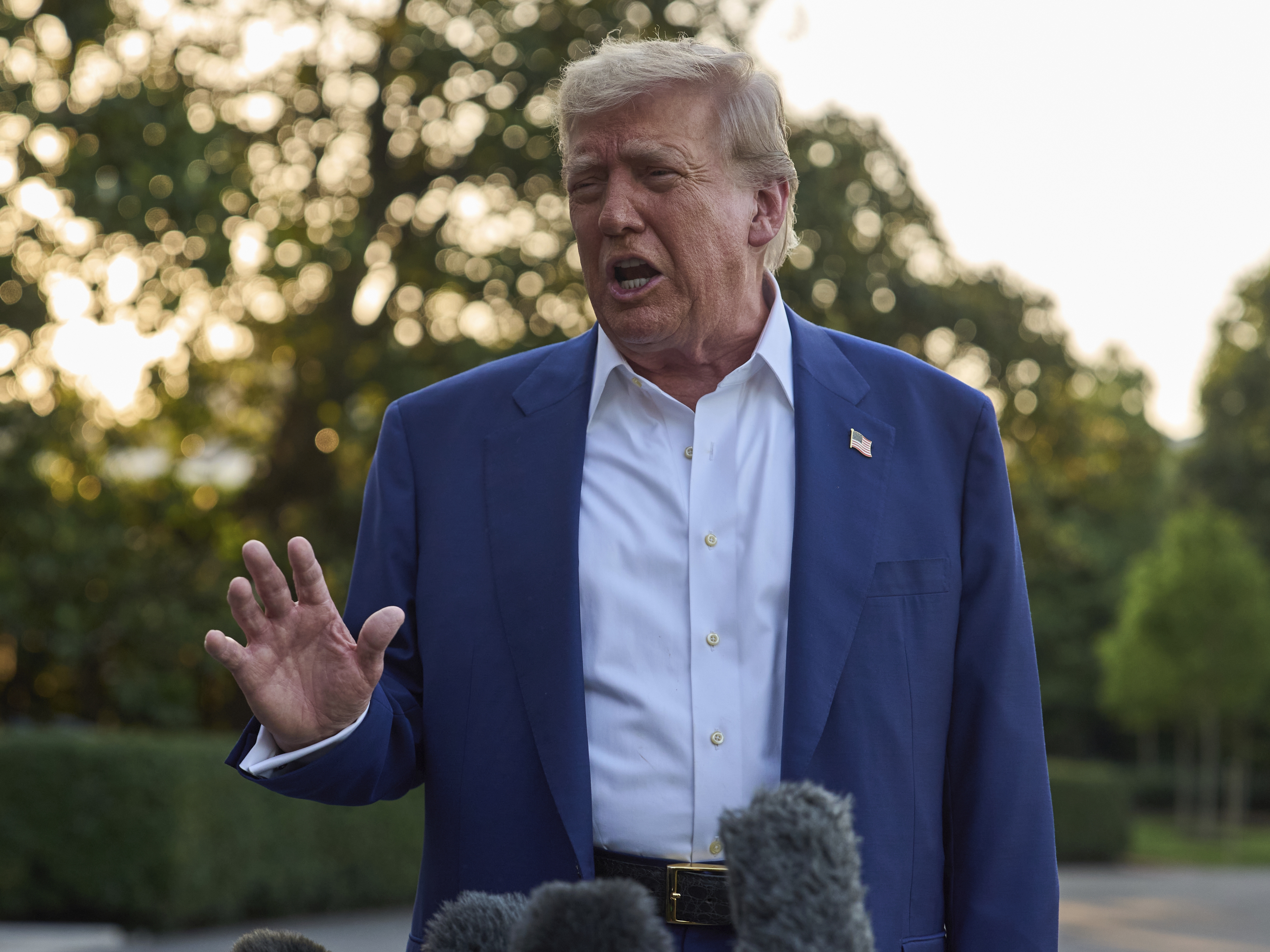 caption: President Trump speaks with reporters before boarding Marine One on the South Lawn of the White House, Tuesday.