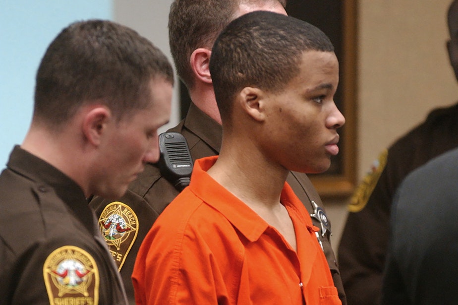 caption: In this Oct. 20, 2003 file photo, Lee Boyd Malvo listens to court proceedings during the trial of fellow sniper suspect John Allen Muhammad in Virginia Beach, Va. An attorney for Malvo, convicted as a teenager of taking part in deadly sniper attacks that terrorized the Washington area, will argue before a Maryland judge that his young client’s life sentence is unconstitutional and should be thrown out. (Martin Smith-Rodden, Pool, File/AP)