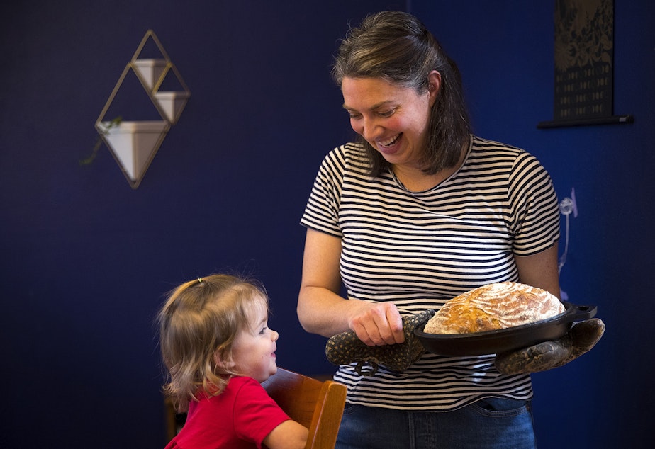 caption: Christina Scheuer shows homemade sourdough bread to her daughter Adrienne while posing for a portrait on Friday, December 20, 2019, at her home in Seattle.