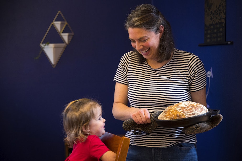 caption: Christina Scheuer shows homemade sourdough bread to her daughter Adrienne while posing for a portrait on Friday, December 20, 2019, at her home in Seattle.