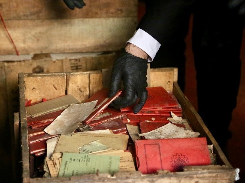 caption: Documents unearthed from wooden crates in the basement of Argentina's top court included Nazi notebooks, photographs and postcards.