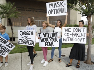 caption: Anger over issues such as the mask mandate galvanized families — like these seen at the Hillsborough County School Board in Tampa, Fla., last year — into running for school board. Progressive groups are taking a leaf out of their playbook.