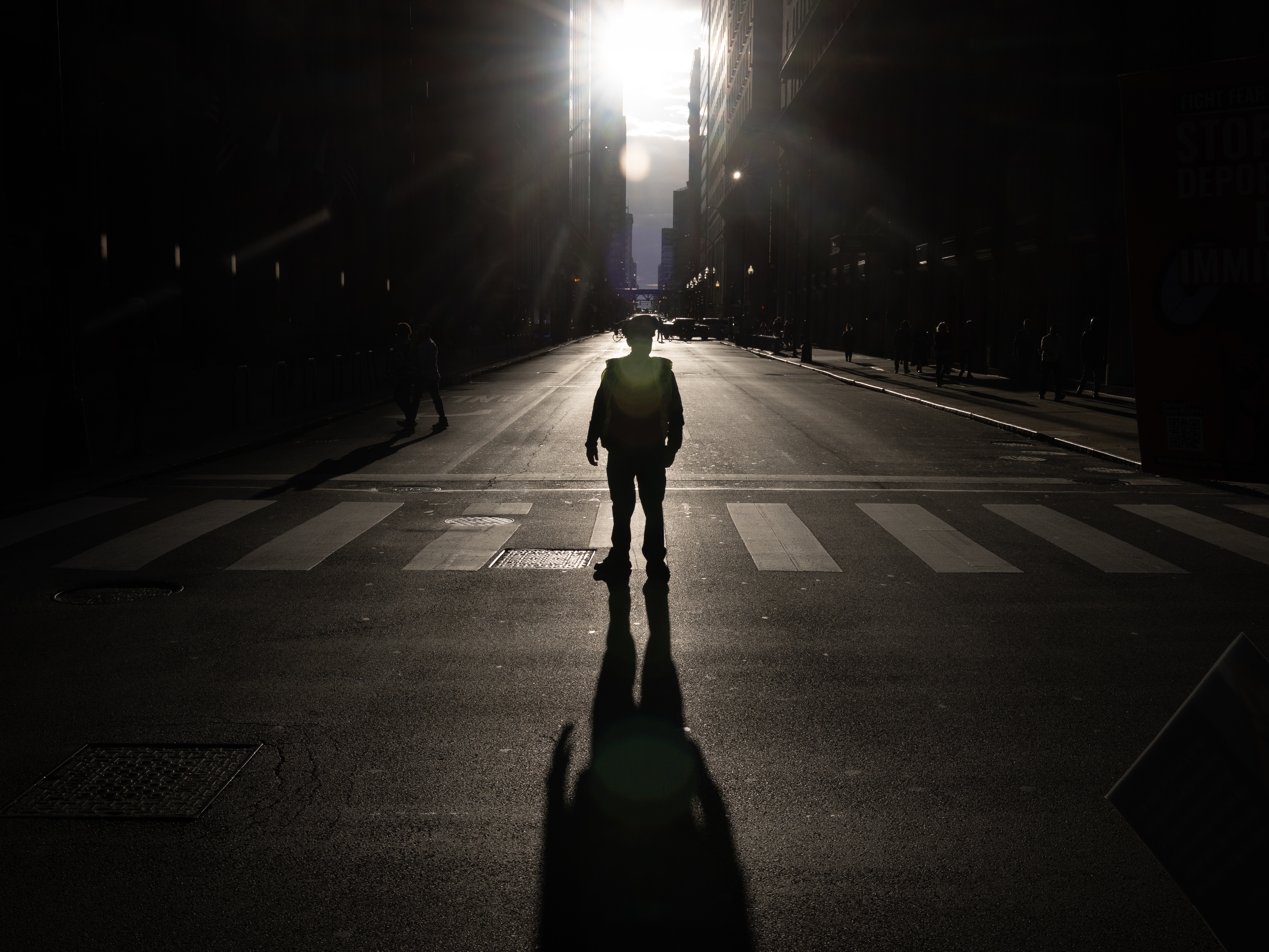 caption: A police officer stands guard as demonstrators marched through downtown Chicago this fall, protesting President Trump's show of federal force aimed at immigration enforcement in the city. Trump called Chicago the "most dangerous city in the world," though crime has fallen there in recent years. <br>