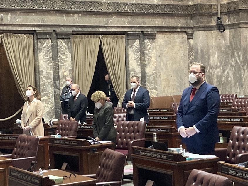 caption:  A limited group of masked state senators participated in-person on the opening day of Washington's 2021 legislative session. Everyone else joined remotely. The 2022 legislative session may look similar in light of rising COVID-19 cases.