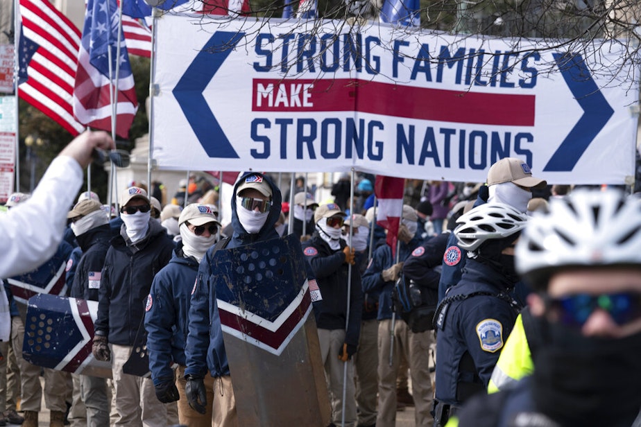 caption: Members of the white supremacist group Patriot Front march on Constitution Avenue near the National Archives in Washington, Friday, Jan. 21, 2022.