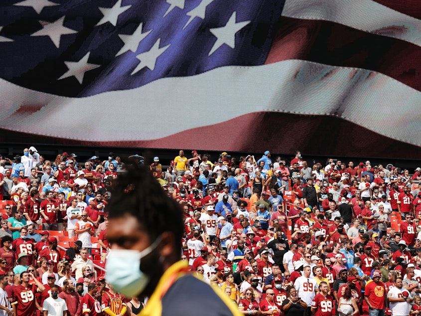 caption: In the past three days, nearly 100 NFL players have tested positive for COVID-19.