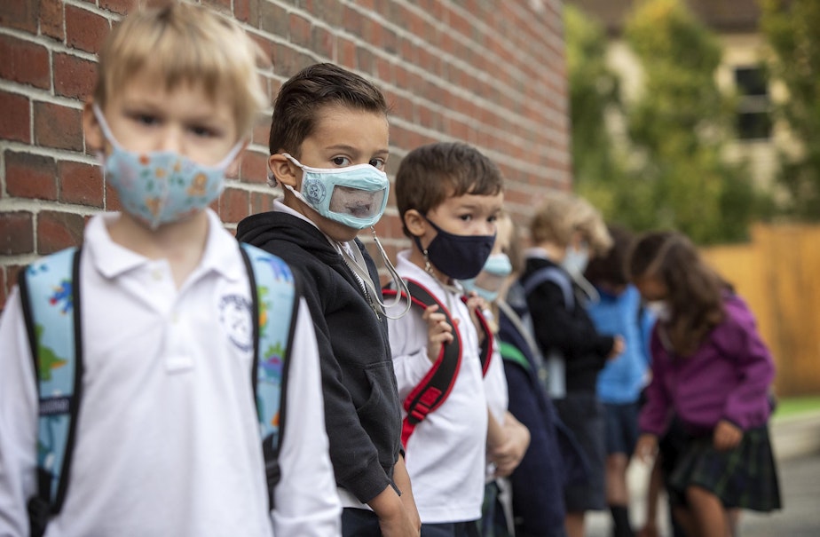 caption: Kindergarten students at St. Peter School wait in a line outside before heading into school in the morning. (Robin Lubbock/WBUR)