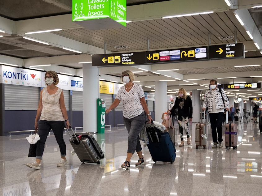 caption: Tourists arrive at Palma de Mallorca, Spain, last summer. The EU's executive arm has proposed a certificate to ease travel across its member states.
