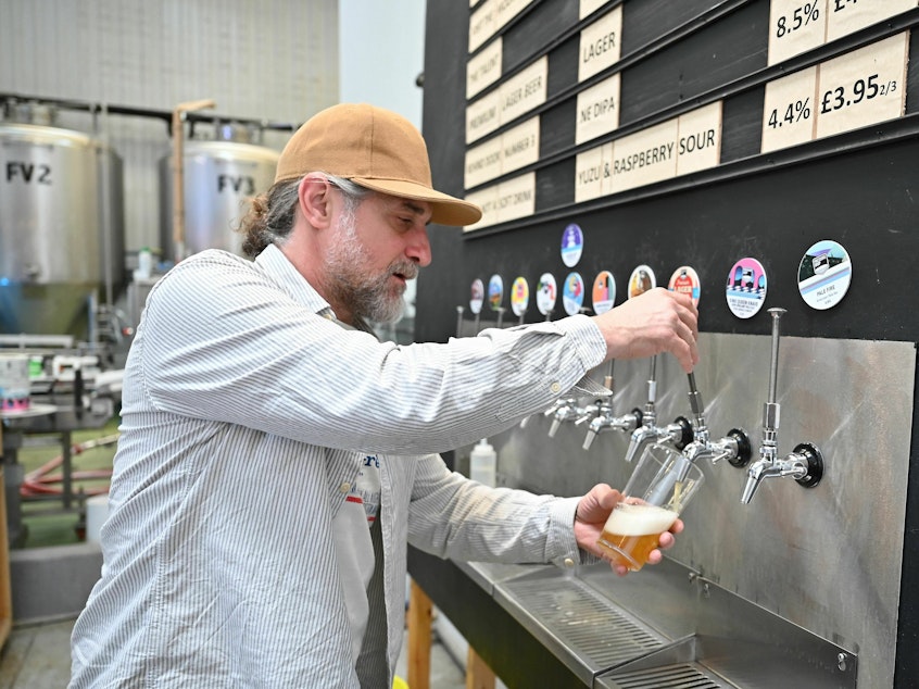 caption: A worker pours a pint of beer at London's Pressure Drop Brewery, one of 61 U.K. employers that participated in a six-month trial of a four-day workweek.