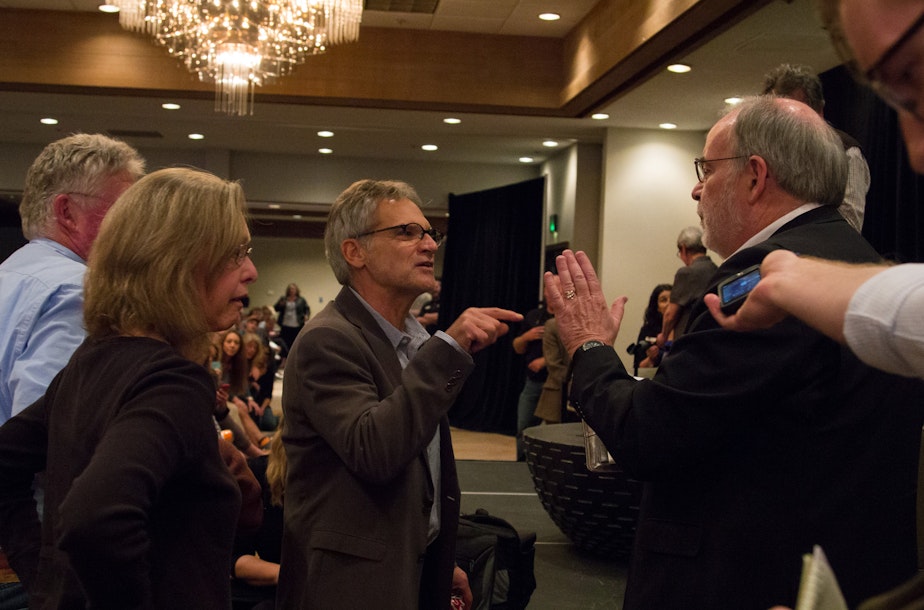 caption: A man identifying himself as Missoula attorney Thomas Dove, right, elbows his way to the stage at a forum open to the public on May 6, accusing author Jon Krakauer, center, of lying and using confidential documents in his new book about rape in Missoula.