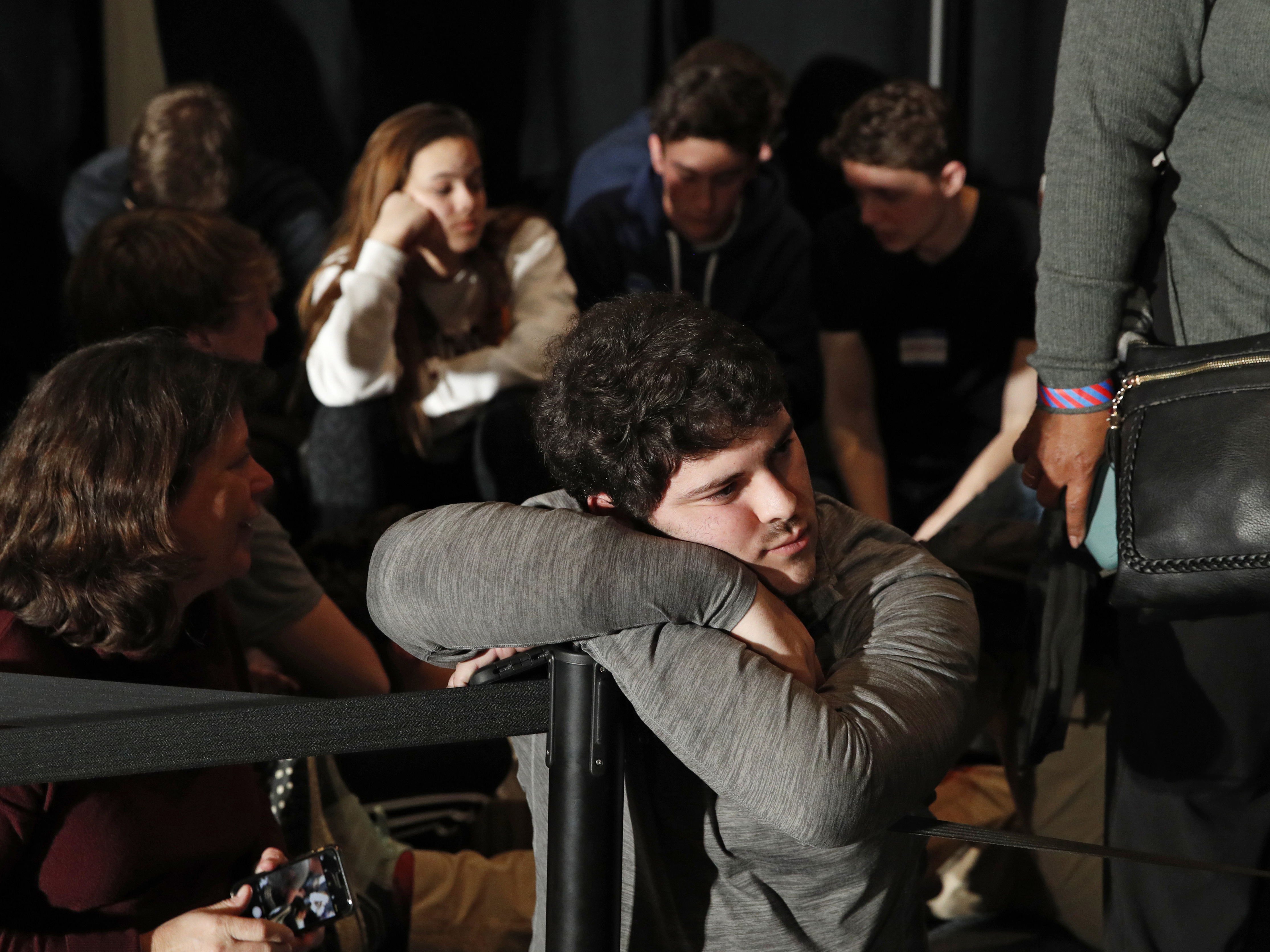 caption: People wait for results at a caucus night campaign rally for former Vice President Joe Biden on Monday in Des Moines, Iowa.