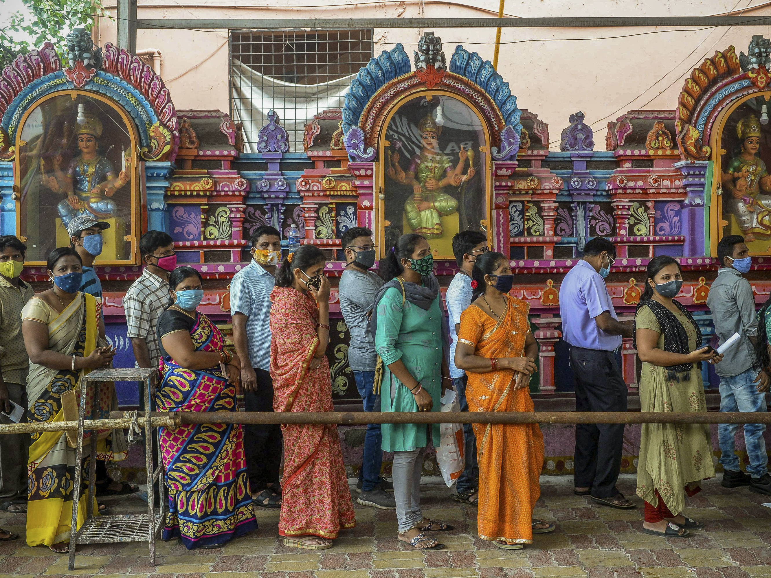 caption: On June 25, people queued up to register for a COVID-19 vaccine at a site outside a Hindu temple in Hyderabad. Vaccinations are now being administered after a series of missteps led to a shortage of doses. If all goes well, India's public health agency hopes to be vaccinating up to 10 million people a day by late July.