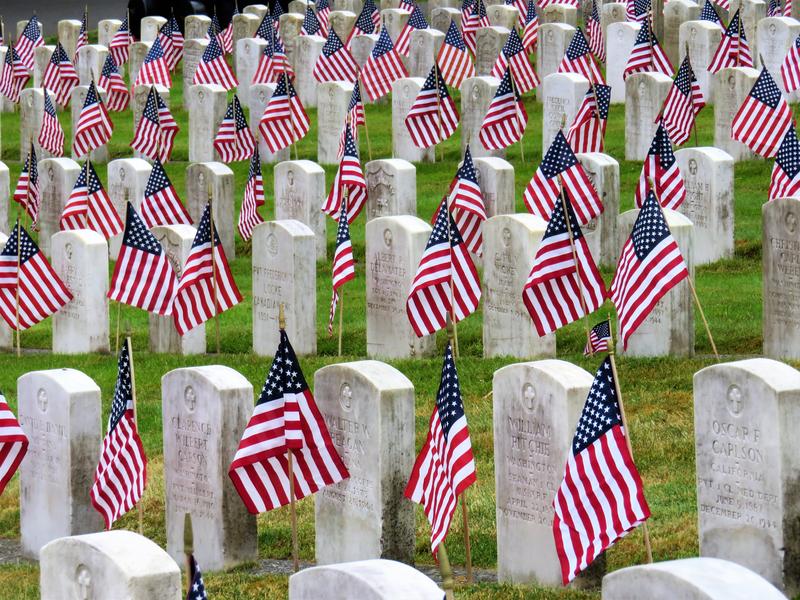 caption: Volunteers started at 7 a.m. to cover each gravestone.
